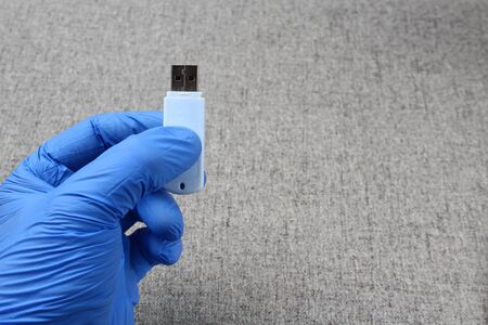 A flash drive in a hand wearing a medical glove. Medical Secret Conceptの写真素材