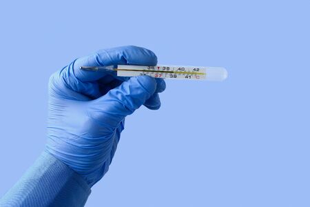 Extremely accurate mercury thermometer in the doctors hand shows elevated temperature on a classic...