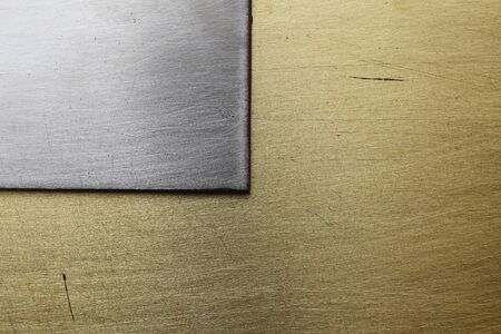 Old scratched metal. Corner of a steel plate on a copper backgroundの写真素材