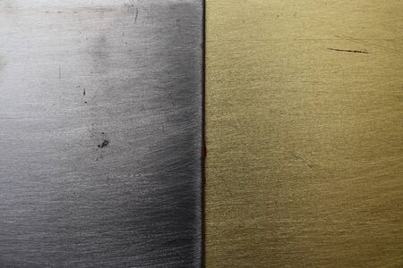 Two different textures of steel and bronze or brass, bisected backgroundの写真素材