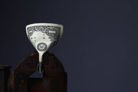 US dollars sandwiched in an old vice, tonedの写真素材