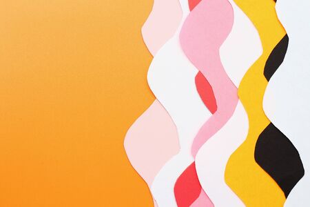 Space for text on an orange background and abstract curved lines of colored paper, background
