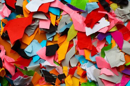 Torn small pieces of multi-colored paper, bright colorful backgroundの写真素材