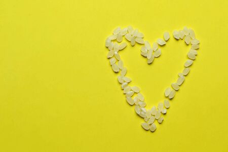 White rice in the shape of a heart, abstract beautiful background