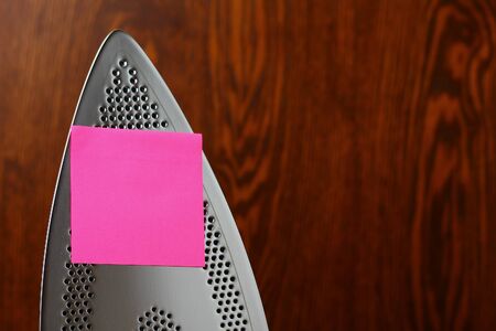 Iron and blank sticker with copyspace as a symbol of remote work from home during the Covid-19 pandemicの写真素材