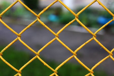 Colored chain link fence with blurry backgroundの写真素材