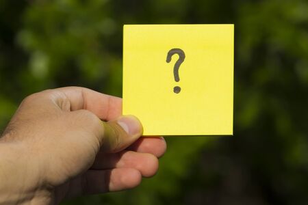 Sticker with a question mark in hand with copy space for text or inscription. Concept: what, where...
