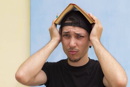 Young student with a book on her head in the shape of a houseの写真素材