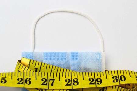 Centimeter or inch tape and medical surgical mask, backgroundの写真素材
