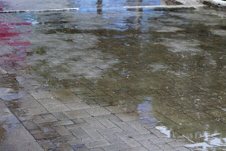 Large pedestrian impassable puddles in an urban environment on a rainy day