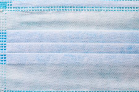 Close-up texture of a medical surgical mask required to be worn in public places during a pandemic...