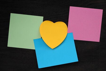 Stickers of different shapes and colors on a black wooden background. Copy space for inscription or text.の写真素材