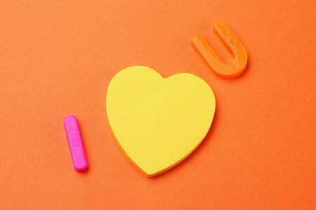 Letters I and U with a blank symbolic heart shaped sticker. Short Message I love you. Backgroundの写真素材