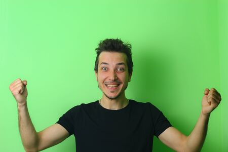 Expressive young man or guy on a light green background. The emotion of happiness and joyの写真素材