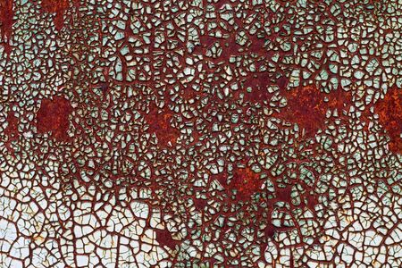 Peeling and cracked light paint on an old rusty metal surface. Grunge textured background