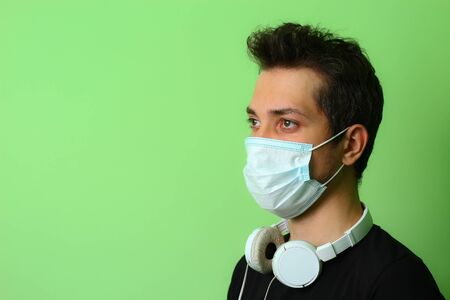 Expressive young man or guy on a light green background. Serious and focused on workの写真素材