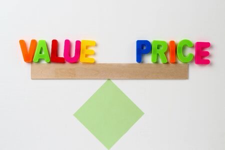 Text made in multicolored magnetic letters. VALUE PRICE. White wooden background.の写真素材