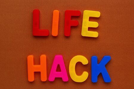 Text made in multicolored magnetic letters. LIFE HACK. Color paper backgroundの写真素材