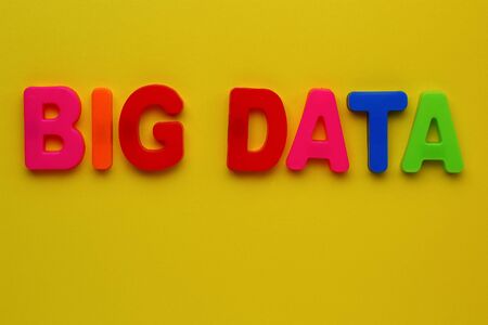 Text made in multicolored magnetic letters. BIG DATA. Yellow backgroundの写真素材