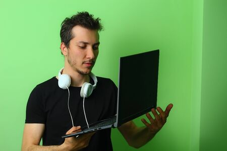 Expressive young man or guy on a light green background. Serious and focused on workの写真素材