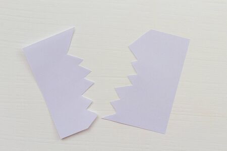 Cut paper sticker on white wooden table. Background with copyspace. Mockup