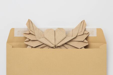 Origami paper heart mockup. Selective focus. Against the background of a classic mail envelope.の写真素材