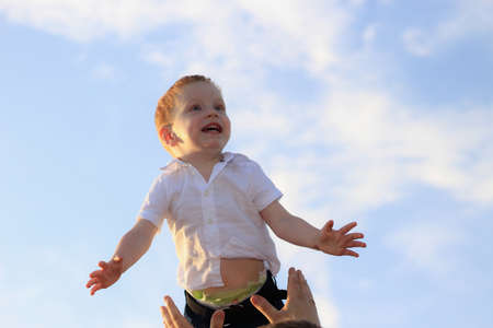 Lifestyle photo shoot of a real family in nature. Mom, dad and son enjoy a walk through the fresh air and the scent on the lavender field in the rays of the setting sun. Selective focus.の写真素材