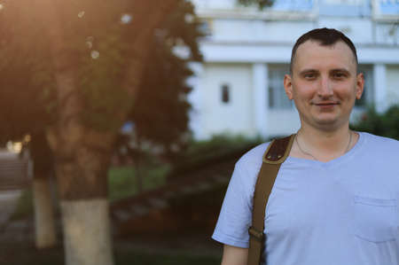 White young man or adult guy walks in the park. Toned background.