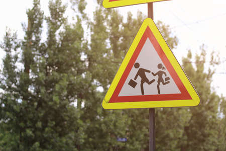 Sign caution children in the sunshine on a hot summer day. Toned background.
