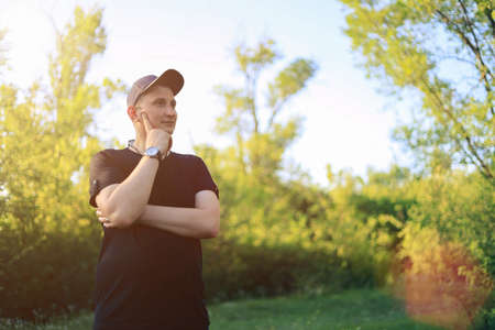 White young man or adult guy walks in the park. Toned background.の写真素材