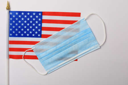 American patriotic small flag and medical surgical mask, background.