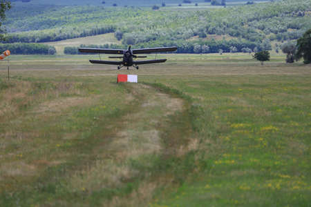 Classic old retro vintage airplane with propeller approach at the airfield.