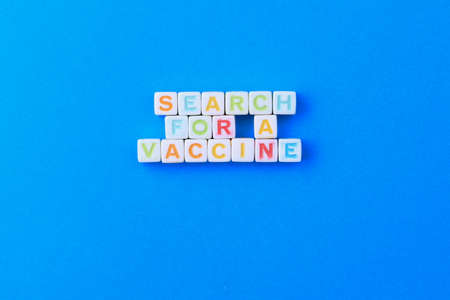 Cubes form the text Search for a vaccine on the classic blue medical background.の写真素材