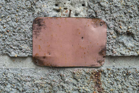 Old metal plaque on the building with copy space. Blank slab for text. Mockup