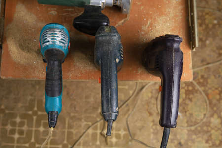 Old reliable corded power tool in a workshop. Handles for drills and screwdrivers. Selective focus...