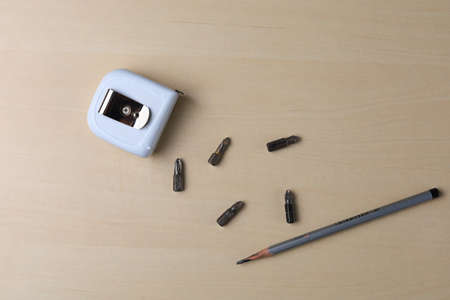 Old used screwdriver bits, tape measure and pencil. Carpenter background or custom-made furniture craftsman.の写真素材