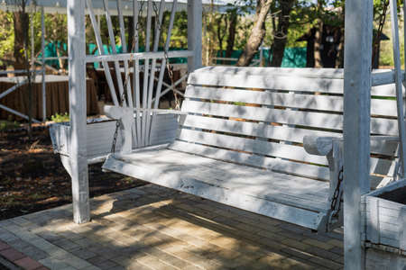 Outdoor benches for relaxation and enjoyment in contrasting light. Selective focus with blurred backgroundの写真素材