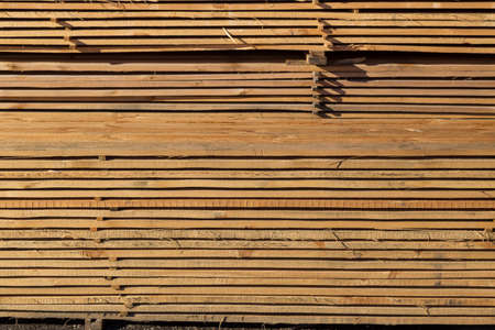 Wood planks for sale. Stacks of processed wood at the timber yard. Background