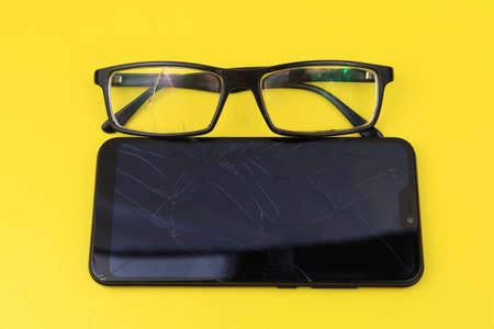 Broken glasses and smartphone. Selective focus. Background