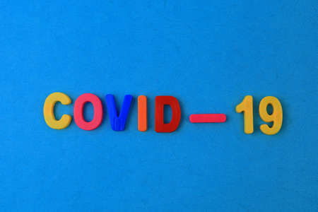 A word or text Covid-19 written in a childrens alphabet with classic letters on a magnet.