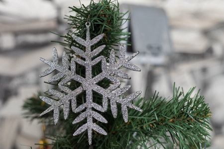 Snowflake on an artificial tree. Decor element. Selective focus on blurred background.の写真素材
