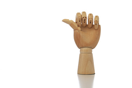 Wooden hand imitating thumb up gesture on white background isolatedの写真素材