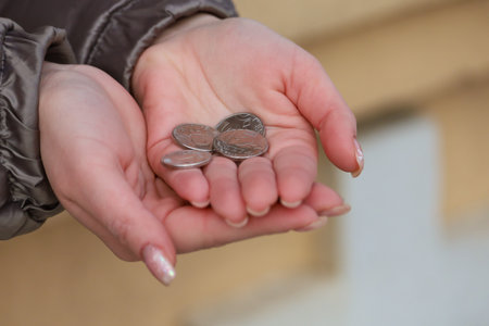 Coins in womens palms. Financial hardship concept. Backgroundの写真素材