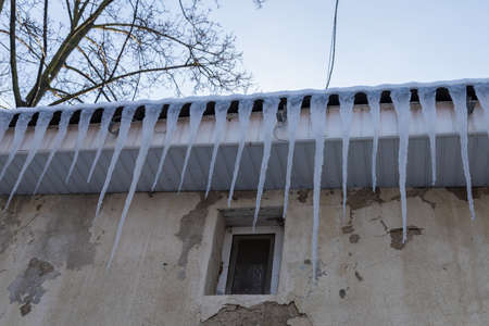 Icicles on the roof of the building. Copy space for text or inscriptions. Backgroundの写真素材