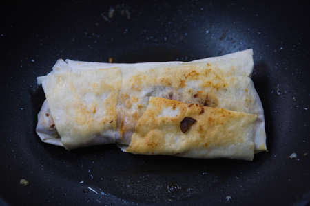 Shawarma or kebab in a pan with selective focus. Home cooking. Background with place for...