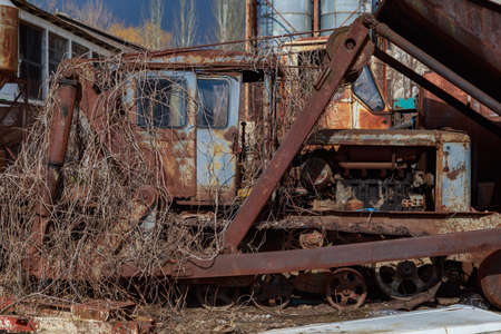 Devastation and decline in the agro-industrial sector. Cemetery of old rusty agricultural machinery. Industrial area. Backgroundの写真素材