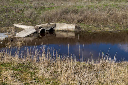 Drainage pipes discharge waste into the river. Ecology and environment problems. Background