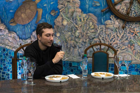 March 26, 2021, Cricova Moldova, young man tasting wine in one of the largest wine cellars in Europe. Background. The main attraction of the country.のeditorial素材
