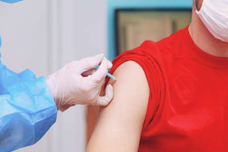 Syringe injection process on real vaccination. Fighting the pandemic. Selective focus with copy...