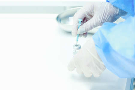 A doctor or nurse draws the  vaccine into a syringe. Selective focus. Background with place for...
